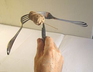 Fork-cork-toothpick object balanced on a pen on the toothpick part