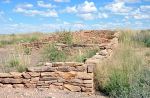 Remains of stone walls rise amid grasses