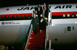 Japan Prime Minister Noboru Takeshita and eleven others deplanes on steps in red colour, from a Japan Air Lines DC-10 marked with an Offical Airline for Expo '90 Osaka, Japan logo and text