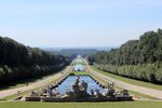 A large park with a pond in the middle, a palace at the far end