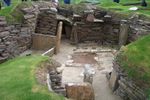 A small depression in the ground reveals a well-preserved excavation site with walls made of rock.