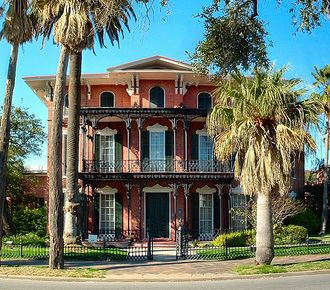 An ornate house with palm trees in front