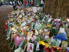 A pile of cards, flowers, and other items left as a memorial