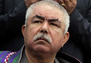 Photograph of Abdul Rashid Dostum wearing a black suit, white shirt, and necktie