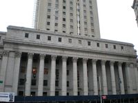 Exterior view of a white building with numerous pillars. An inscription reads "United States Court House".