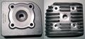 The bottom (left) and top (right) of a Malossi cylinder head for single-cylinder, two-stroke scooters. Hole in the middle for the spark plug, four holes for the cylinder bolt posts.