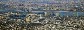 Fort Lee, New Jersey in the foreground, connected by the George Washington Bridge to Upper Manhattan, New York City across the Hudson River, in the background.