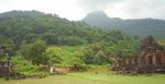 Ruins of stone buildings in a very green lush mountain landscape.