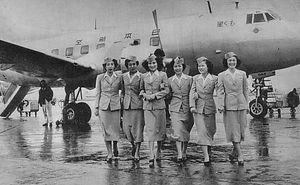 A black and white photograph of a Martin 2-0-2 aircraft with six cabin crew standing in front of the aircraft