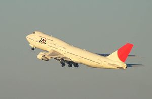 A Boeing 747-300 aircraft in mid air during take-off, with grey sky in the background
