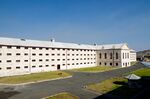 A large white prison building with many windows