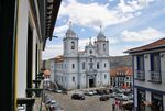 Old church, cobble stone streets and two-storied houses with white facades.