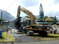 Excavator demolishing a house. Note the hydraulic thumb