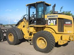 A Caterpillar 930G fitted with a loader rake on a residential construction site in South Florida.