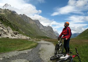 man with mountain bike looking up towards Mont Blanc