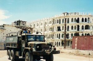 Military truck in front of building