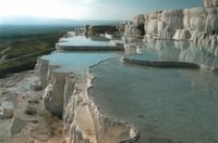 The calcium oxide in the water adds to the thickness of the white layers and widens the terraces, producing pools in fantastic shapes reminiscent of oyster shells or flower petals, while the small amount of sulphur and iron oxide produces stripes of yellow, red and green over the white of the limestone.