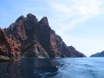 A large rock formation pierces through the ocean's surface.