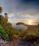 A twilight view of several islands and a sea.