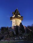 A short but large clock tower shines at dawn.