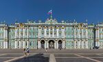 Baroque palace with green and gold facade and a Russian flag on the top