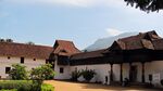 A large building with white walls, red roof, and wooden beams