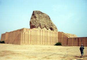 A large, partially restored, brick building with a soldier in front