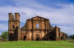 Ruins of a stone church facade and tower.